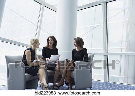 Businesswomen sitting in armchairs talking View Large Photo Image Stock Image - Businesswomen sitting in armchairs talking. Fotosearch