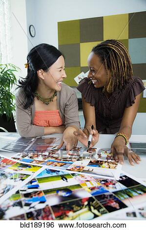 Stock Photograph - Businesswomen working together in office. Fotosearch