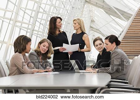 Stock Image - Busy businesswomen meeting in conference room. Fotosearch