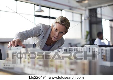 Picture - Caucasian architect examining architectural model in office. Fotosearch
