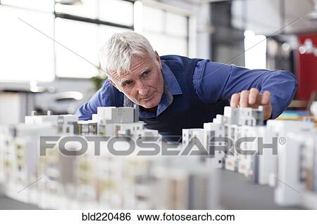 Caucasian architect examining architectural model in office View Large Photo Image Stock Photograph - Caucasian architect examining architectural model in office. Fotosearch