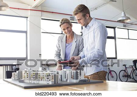 Caucasian architects examining architectural model in office View Large Photo Image Stock Image - Caucasian architects examining architectural model in office. Fotosearch