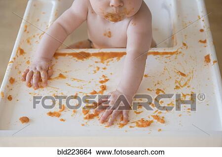 Caucasian baby girl self-feeding mashed sweet potato View Large Photo Image Picture - Caucasian baby girl self-feeding mashed sweet potato. Fotosearch