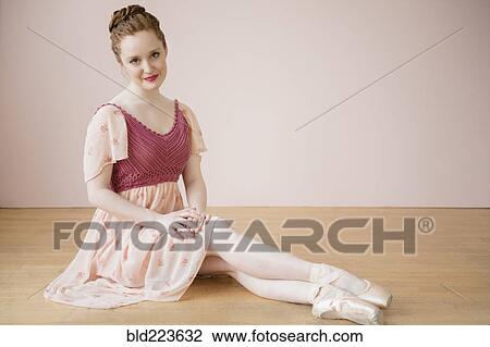 Stock Image - Caucasian ballerina sitting on floor. Fotosearch