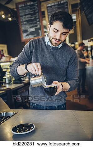 Stock Image - Caucasian barista making coffee in cafe. Fotosearch
