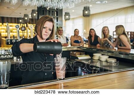 Caucasian bartender pouring cocktail from mixer into glass View Large Photo Image Stock Photo - Caucasian bartender pouring cocktail from mixer into glass. Fotosearch