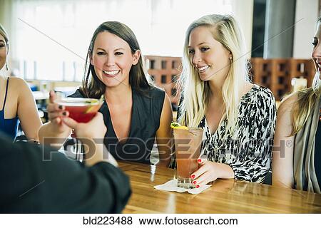 Caucasian bartender serving martini cocktail to customer View Large Photo Image Stock Photo - Caucasian bartender serving martini cocktail to customer. Fotosearch