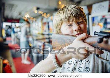 Caucasian boy aiming gun in arcade shooting game View Large Photo Image Stock Image - Caucasian boy aiming gun in arcade shooting game. Fotosearch