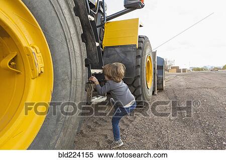 Caucasian boy climbing ladder on tractor View Large Photo Image Stock Photography - Caucasian boy climbing ladder on tractor. Fotosearch