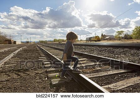 Caucasian boy crossing railroad tracks View Large Photo Image Stock Photo - Caucasian boy crossing railroad tracks. Fotosearch
