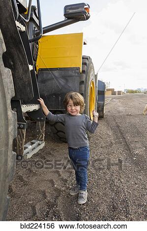 Caucasian boy holding ladder on tractor View Large Photo Image Stock Photograph - Caucasian boy holding ladder on tractor. Fotosearch