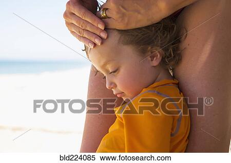 Caucasian boy leaning on legs of mother View Large Photo Image Stock Photography - Caucasian boy leaning on legs of mother. Fotosearch