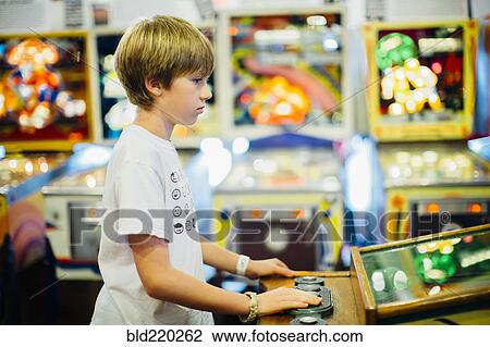 Caucasian boy playing video game in arcade View Large Photo Image Stock Image - Caucasian boy playing video game in arcade. Fotosearch