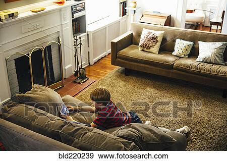 Caucasian boy using cell phone in living room View Large Photo Image Stock Photo - Caucasian boy using cell phone in living room. Fotosearch