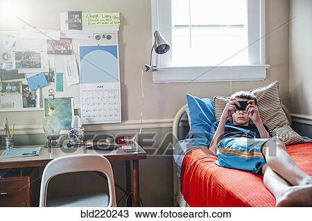 Caucasian boy using cell phone on bed View Large Photo Image Stock Image - Caucasian boy using cell phone on bed. Fotosearch