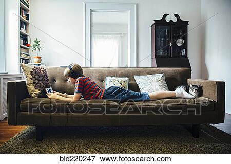 Caucasian boy using digital tablet on sofa View Large Photo Image Stock Photo - Caucasian boy using digital tablet on sofa. Fotosearch