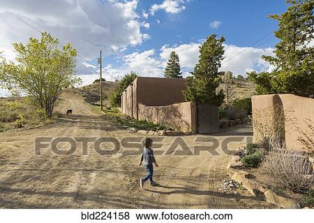 Caucasian boy walking on dirt road toward gate View Large Photo Image Stock Photo - Caucasian boy walking on dirt road toward gate. Fotosearch