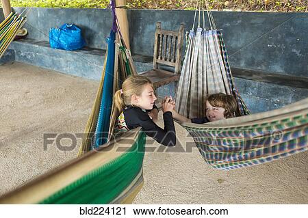 Caucasian brother and sister laying in hammocks holding hands View Large Photo Image Stock Image - Caucasian brother and sister laying in hammocks holding hands. Fotosearch