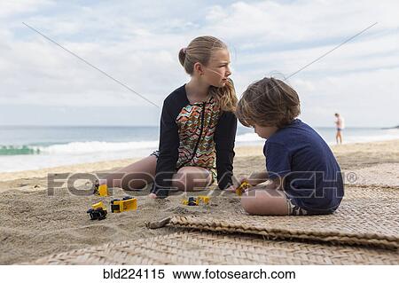 Stock Photography - Caucasian brother and sister playing with toys at beach. Fotosearch