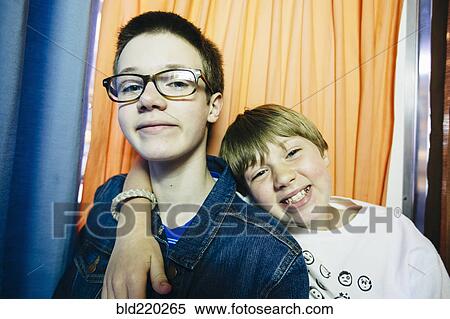 Stock Photography - Caucasian brothers smiling in photo booth. Fotosearch