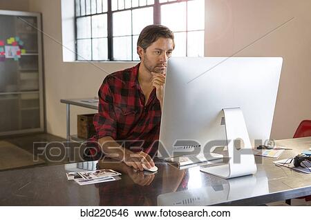 Stock Photograph - Caucasian businessman using computer in office. Fotosearch