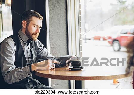 Caucasian businessman using digital tablet in cafe View Large Photo Image Picture - Caucasian businessman using digital tablet in cafe. Fotosearch