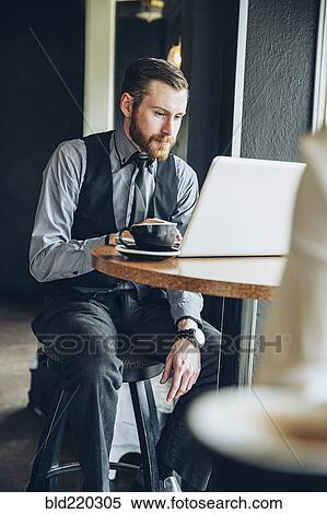 Caucasian businessman using laptop in cafe View Large Photo Image Stock Photography - Caucasian businessman using laptop in cafe. Fotosearch
