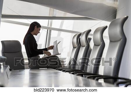 Caucasian businesswoman sitting on conference table reading notepad View Large Photo Image Stock Image - Caucasian businesswoman sitting on conference table reading notepad. Fotosearch