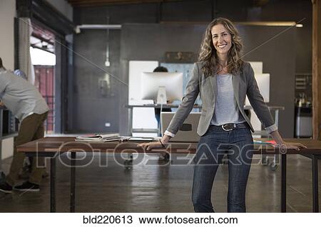 Stock Image - Caucasian businesswoman smiling in office. Fotosearch