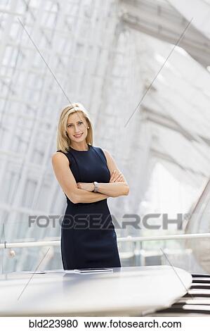Caucasian businesswoman standing with arms crossed in conference room View Large Photo Image Stock Image - Caucasian businesswoman standing with arms crossed in conference room. Fotosearch