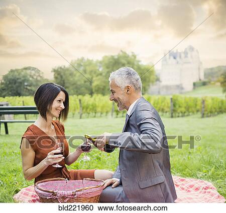 Caucasian couple enjoying wine at picnic View Large Photo Image Stock Image - Caucasian couple enjoying wine at picnic. Fotosearch