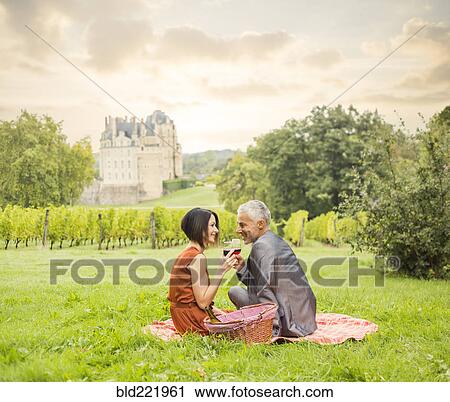 Caucasian couple enjoying wine at picnic View Large Photo Image Stock Image - Caucasian couple enjoying wine at picnic. Fotosearch