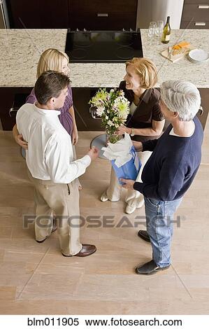 Stock Photography - Caucasian couple giving hosts gift and flowers. Fotosearch