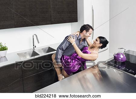 Stock Photo - Caucasian couple hugging in kitchen. Fotosearch