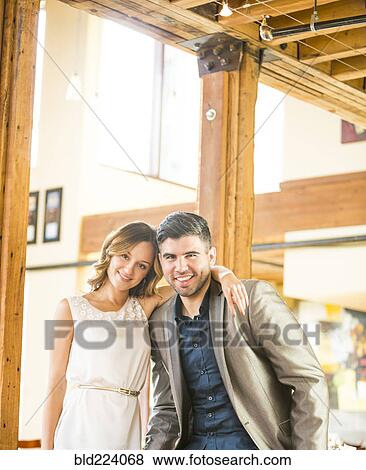 Stock Photo - Caucasian couple hugging near beam. Fotosearch