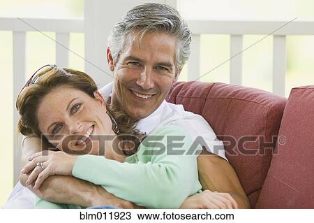 Stock Image - Caucasian couple hugging on porch. Fotosearch