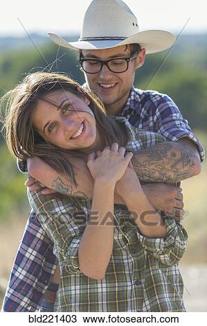 Stock Image - Caucasian couple hugging outdoors. Fotosearch