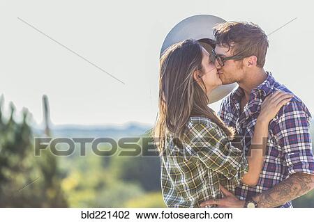 Stock Image - Caucasian couple kissing outdoors. Fotosearch