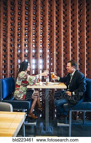 Caucasian couple toasting with cocktails in restaurant View Large Photo Image Stock Image - Caucasian couple toasting with cocktails in restaurant. Fotosearch