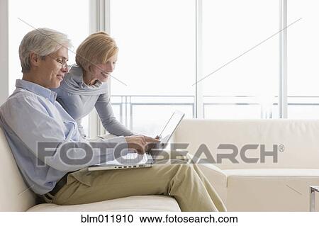 Stock Image - Caucasian couple using laptop together. Fotosearch