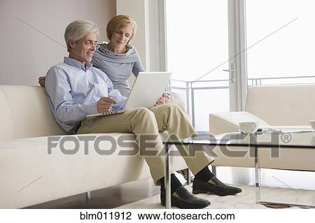 Stock Image - Caucasian couple using laptop together. Fotosearch