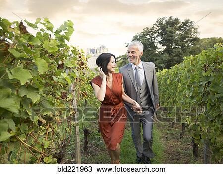 Caucasian couple walking in vineyard View Large Photo Image Stock Image - Caucasian couple walking in vineyard. Fotosearch