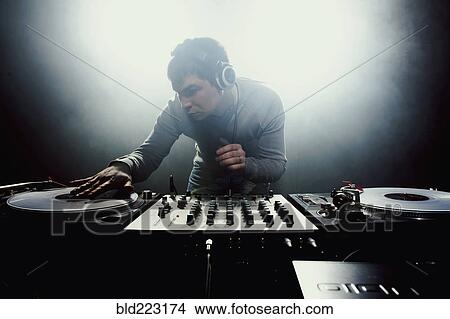 Caucasian disc jockey playing music in nightclub View Large Photo Image Picture - Caucasian disc jockey playing music in nightclub. Fotosearch