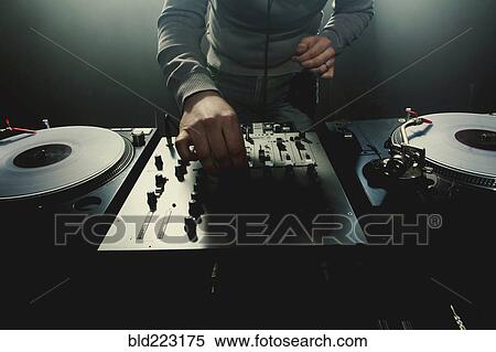 Stock Photography - Caucasian disc jockey playing music in nightclub. Fotosearch