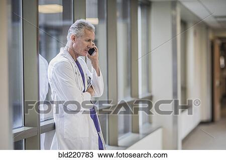 Stock Image - Caucasian doctor talking on cell phone. Fotosearch