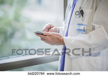 Caucasian doctor using cell phone View Large Photo Image Picture - Caucasian doctor using cell phone. Fotosearch