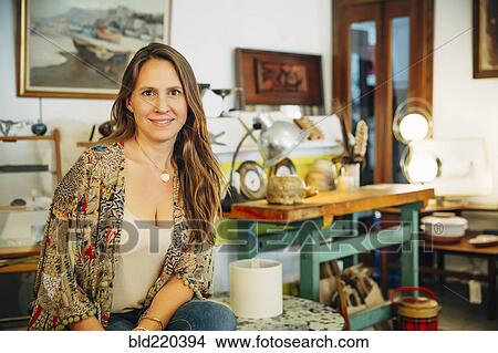 Picture - Caucasian entrepreneur sitting in store. Fotosearch