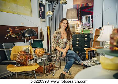 Stock Image - Caucasian entrepreneur sitting in store. Fotosearch