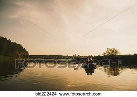Picture - Caucasian family paddling boat on river. Fotosearch