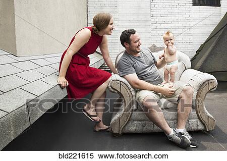 Stock Photography - Caucasian family sitting in armchair outdoors. Fotosearch